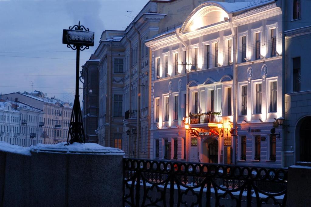 a lit up building with a sign in front of it at Pushka INN hotel in Saint Petersburg