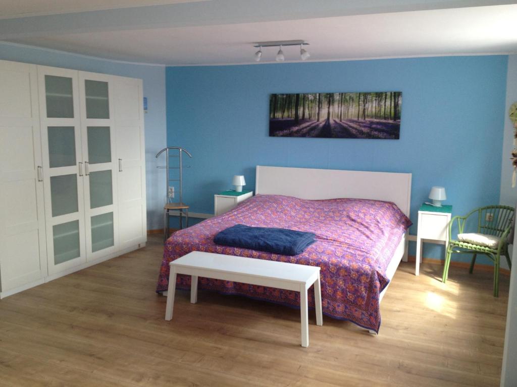 a bedroom with a bed with a purple bedspread at Traumlage-Maasholm in Maasholm