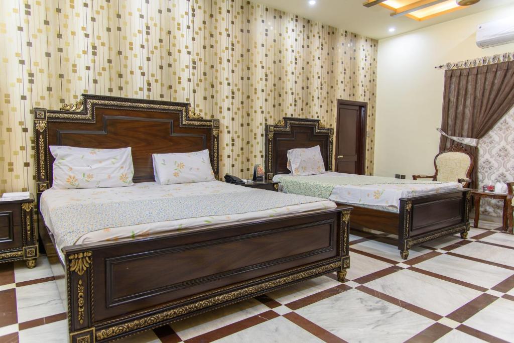 a bedroom with two beds in a room at Patel Residency Guest House in Karachi