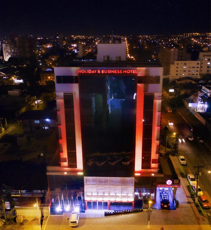 a building with a sign on it at night at Holiday & Business Hotel - Em frente ao Centro de Eventos e Arena Conda in Chapecó