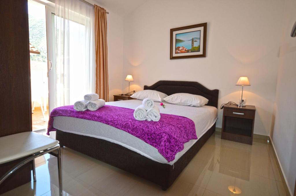 a bedroom with a bed with two towels on it at Apartmani Kovačević in Kotor