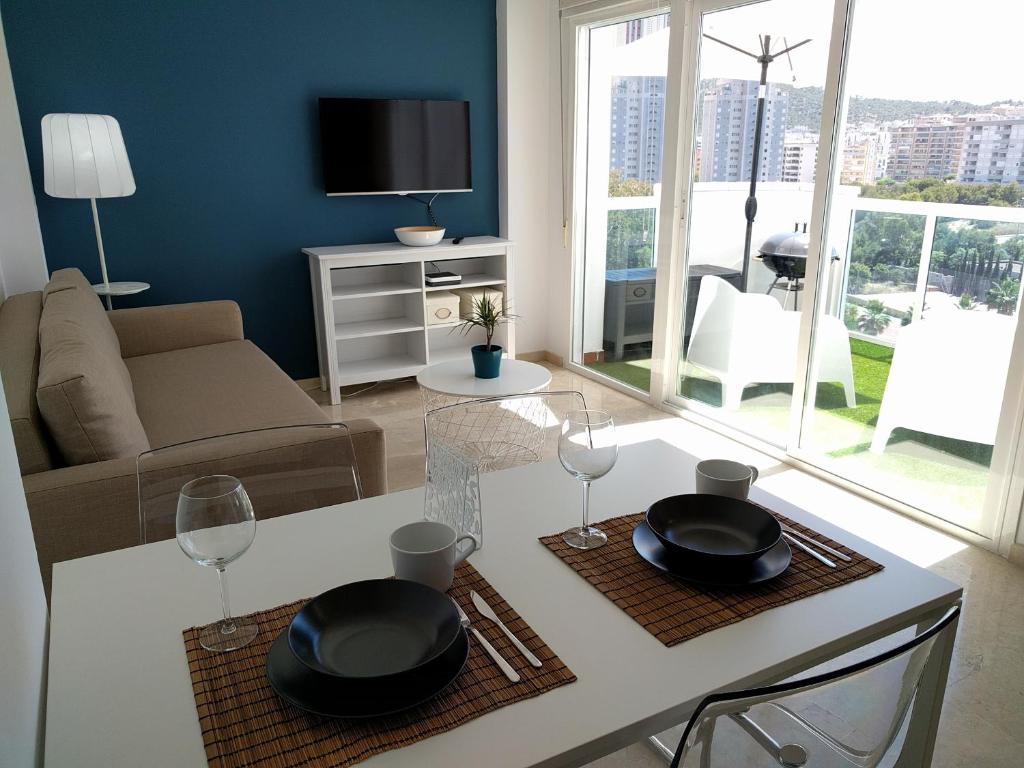 een woonkamer met een tafel met twee wijnglazen bij Apartamento Cala Finestrat in Benidorm