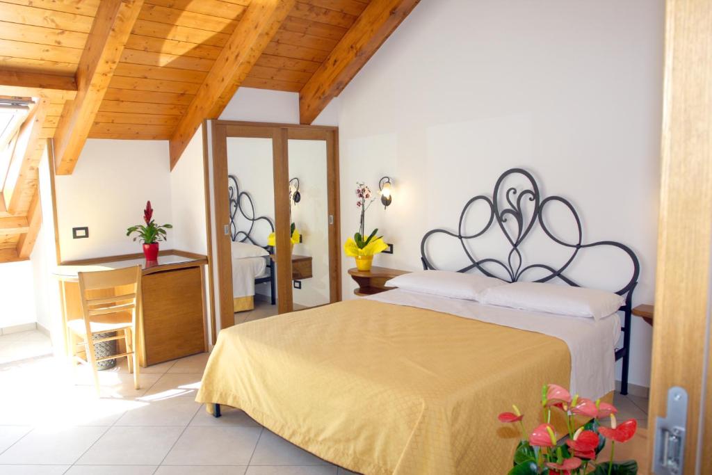 1 dormitorio con cama, mesa y espejo en "Gilda INN Agerola", en Agerola