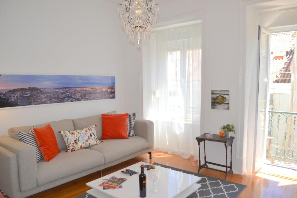 ein Wohnzimmer mit einem Sofa und einem Kronleuchter in der Unterkunft TP MONTE 20, Lisbon Apartment in Lissabon