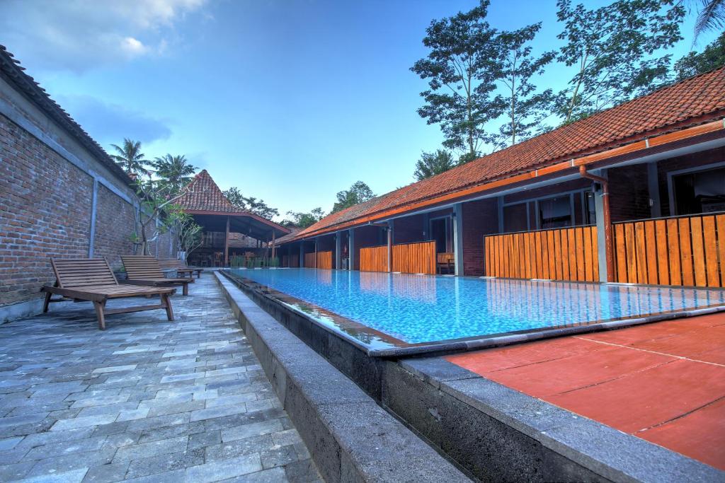 a swimming pool with a bench next to a building at Wahid Borobudur in Borobudur