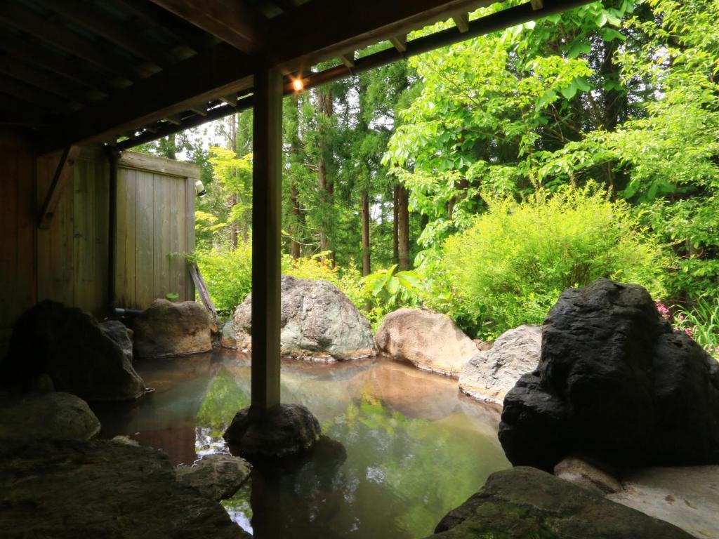 a pool of water with rocks in a yard at Yunohirakan in Takayama