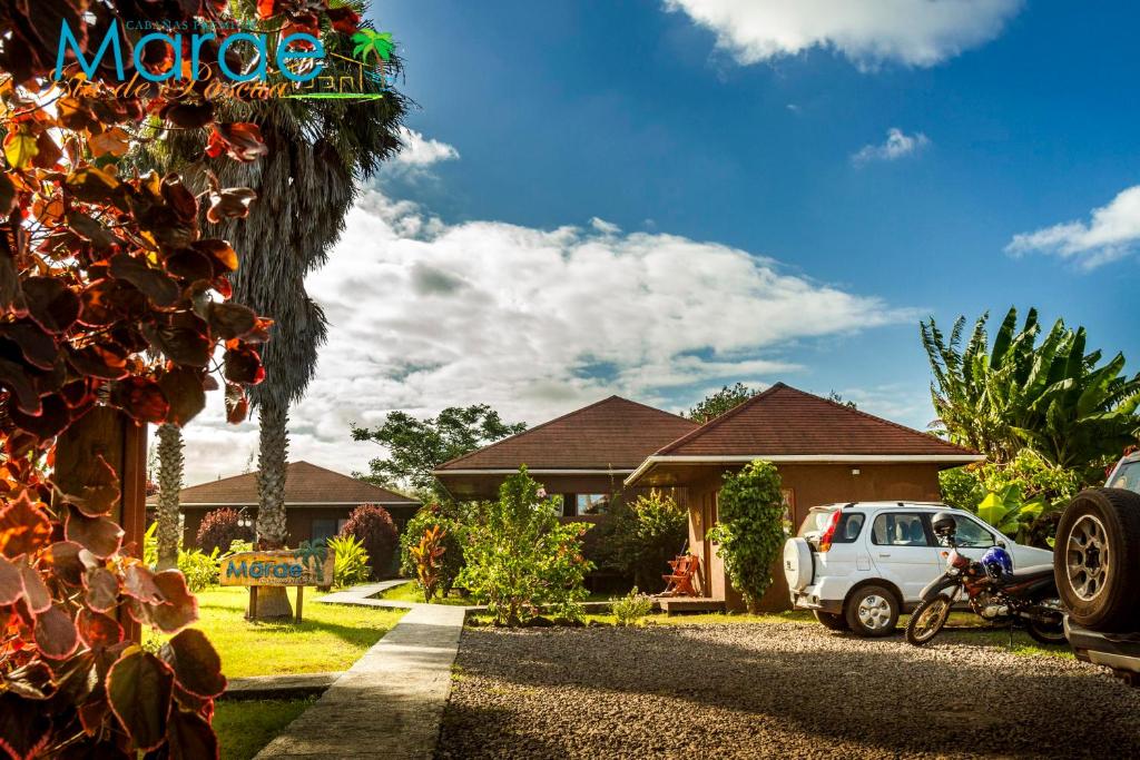a white car parked in front of a house at Marae - Cabañas Premium in Hanga Roa