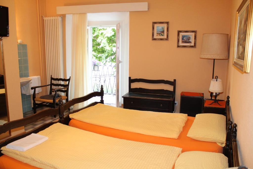 a bedroom with two beds and a window at Osteria Battello in Caslano