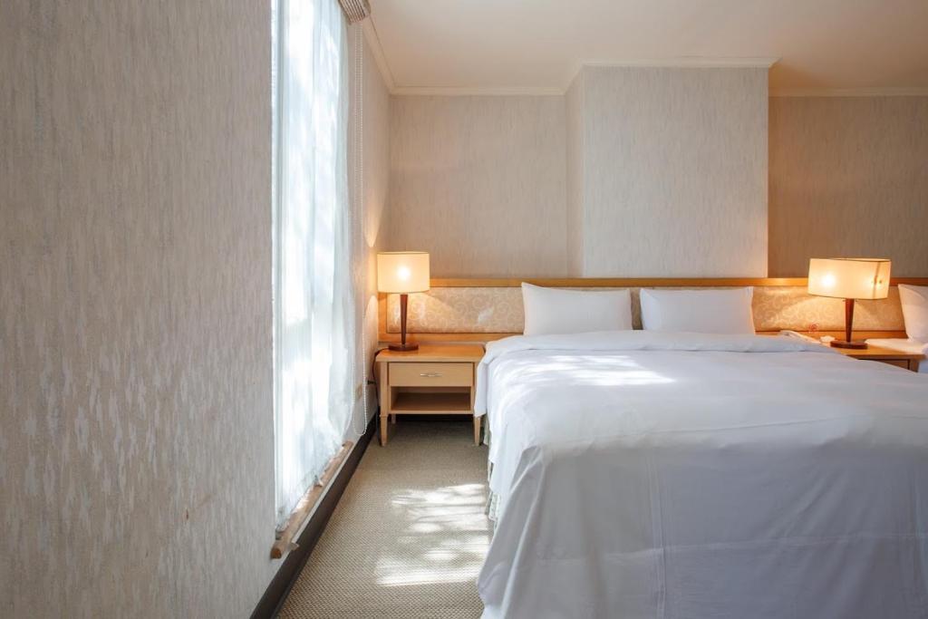 The Koos Hotel في كزينديان: غرفة نوم بسرير ابيض كبير ونافذة