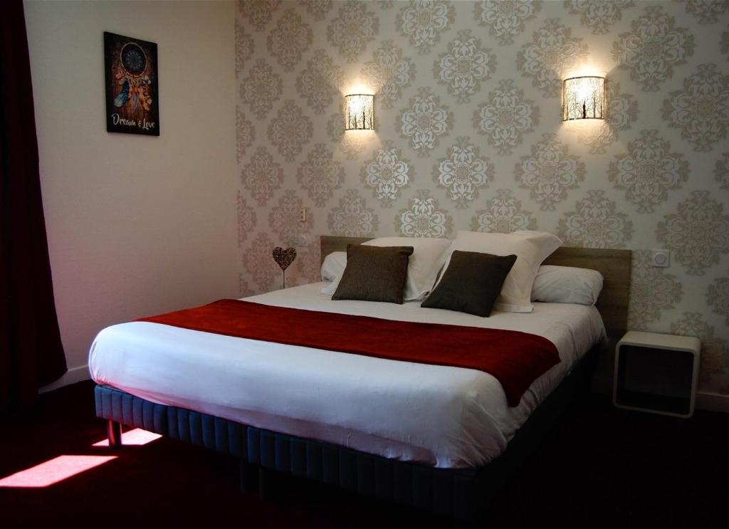 a bedroom with a large bed with two pillows at Le Relax in Aurillac