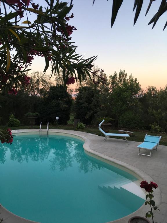 una gran piscina azul con un banco azul junto a ella en Il Lauro, en San Costanzo