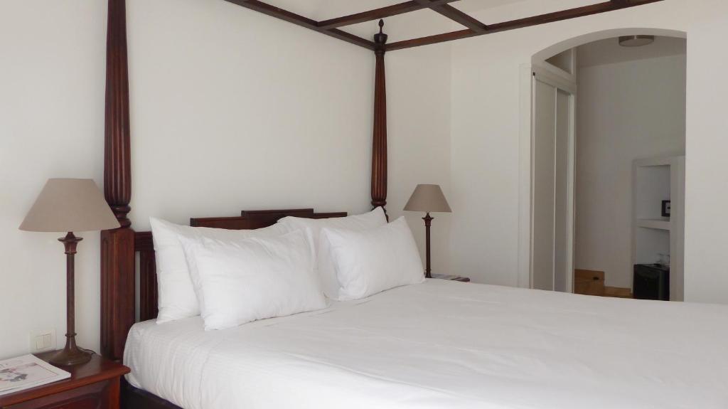 a bedroom with a large white bed with white pillows at Hôtel les Bouis - Vue mer in Saint-Tropez
