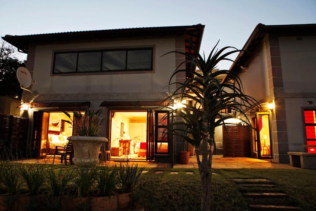 a house with a palm tree in the yard at Aloes No.21 in Amanzimtoti