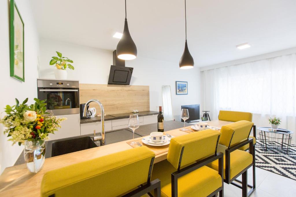 een keuken en eetkamer met een tafel en gele stoelen bij Mateja Apartment in Zagreb