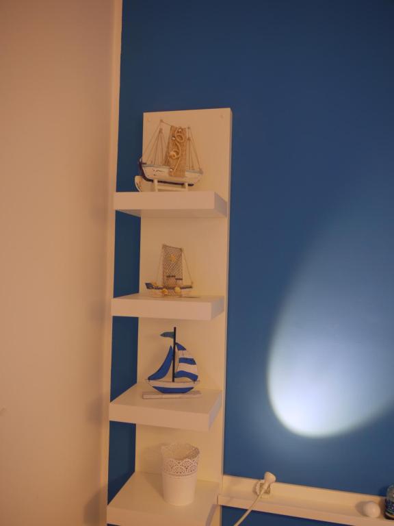 a shelf in a room with two miniature boats on it at White and Blue Holidays in Marina di Modica
