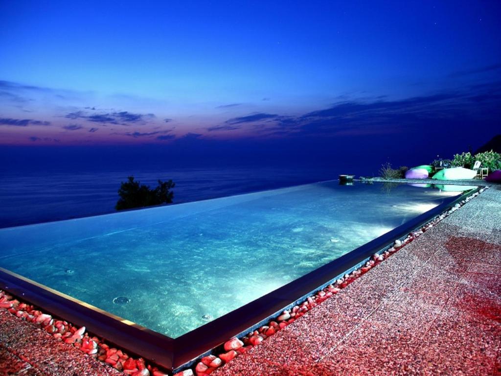 a swimming pool with a view of the ocean at Serenity Boutique Suites in Athanion