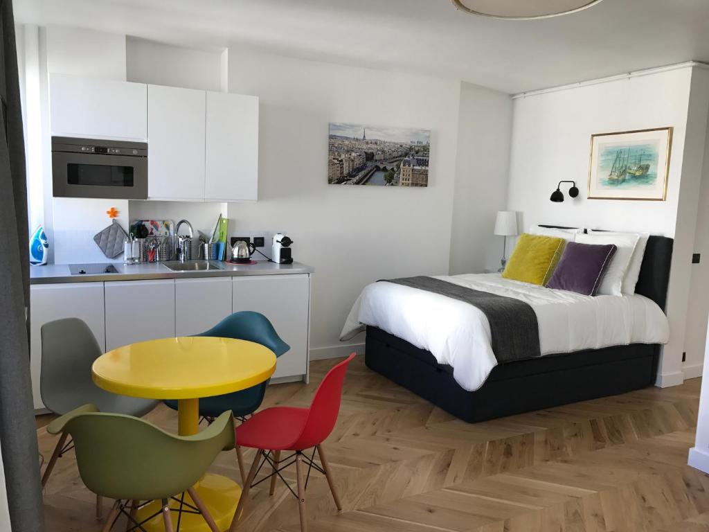 a bedroom with a bed and a table and chairs at Appartement Seine et Marais in Paris