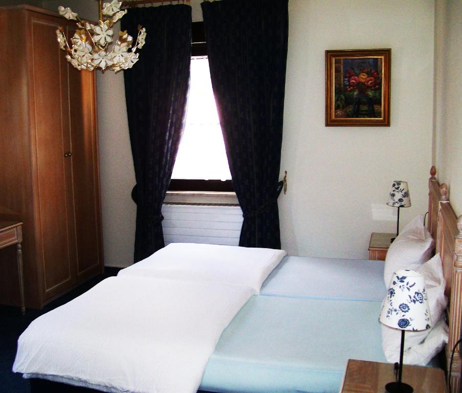 a bedroom with a white bed and a window at Wirtshaus zum Wilddieb in Bad Rappenau