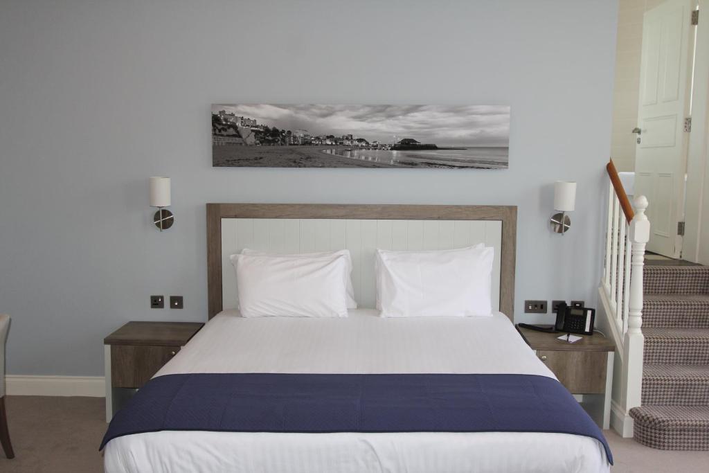 a bedroom with a large white bed with white pillows at Yarrow Hotel in Broadstairs