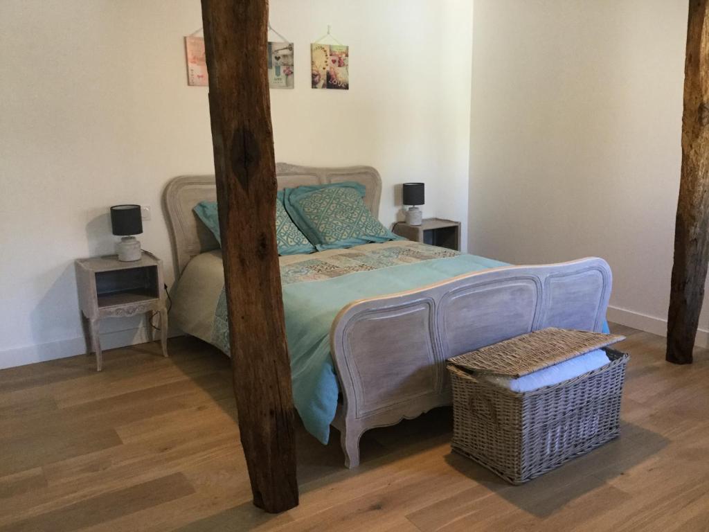 1 dormitorio con 1 cama con poste de madera en Gites de la Marniere, en Mouchamps