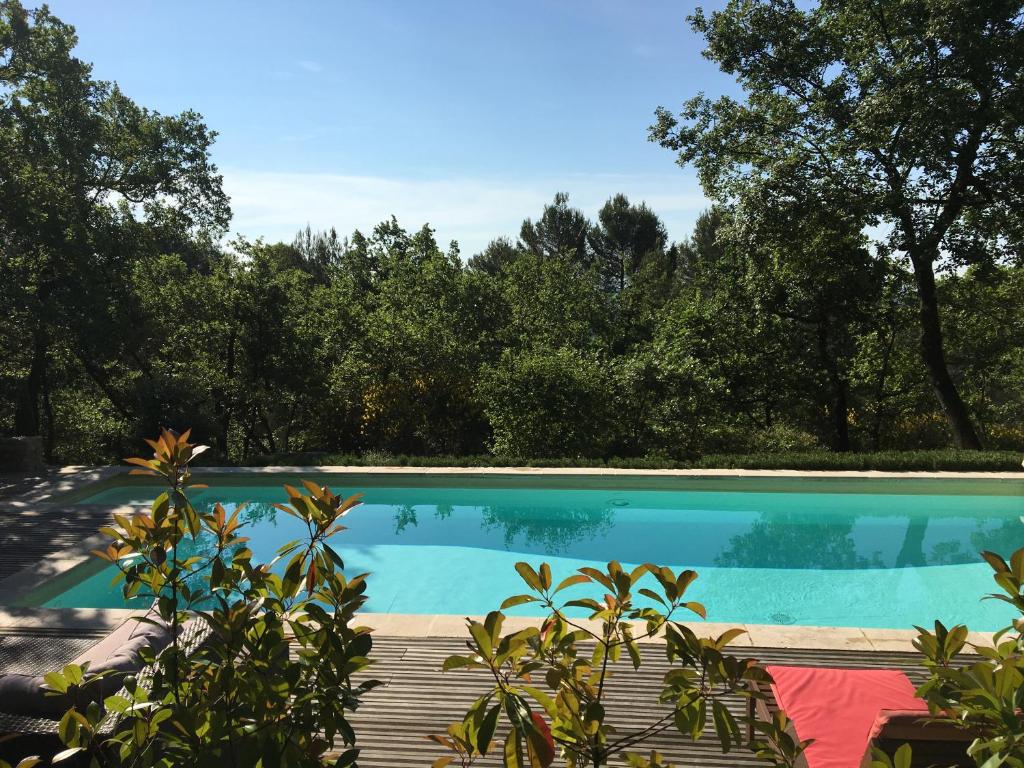 ein Pool mit Bäumen im Hintergrund in der Unterkunft Villa de Carbonelle in Pierrevert