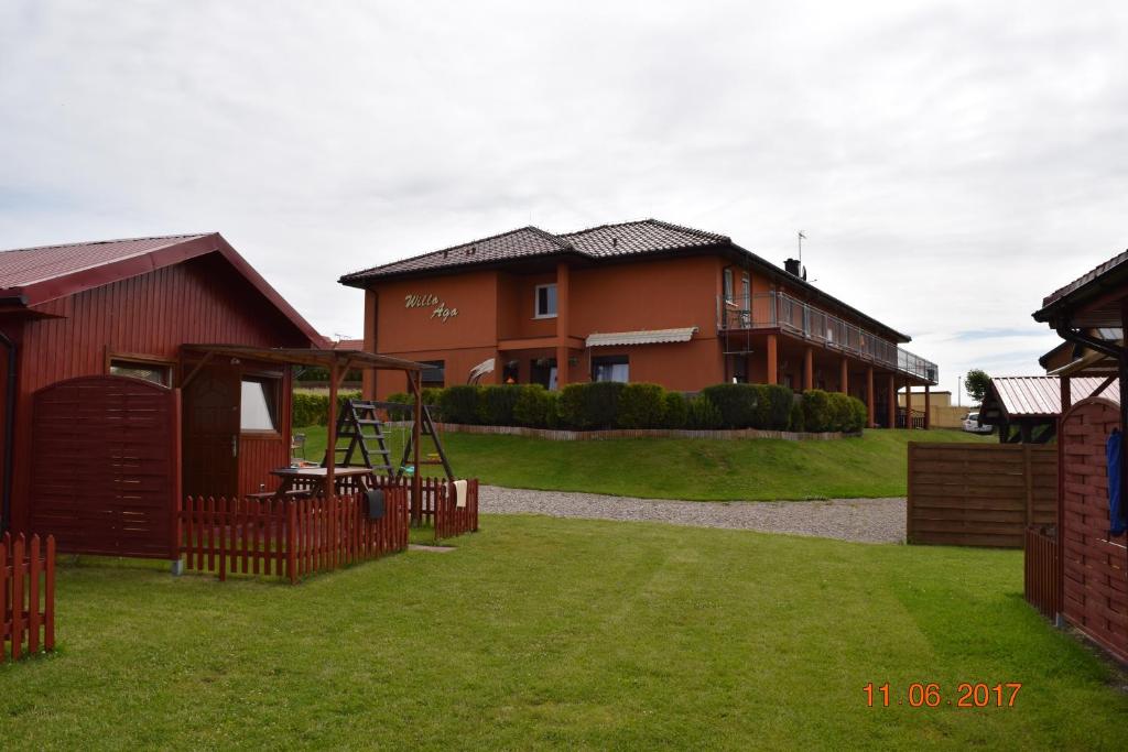 a house with a playground in front of a house at Aga Pokoje Gościnne - Tylko dla dorosłych in Rewal