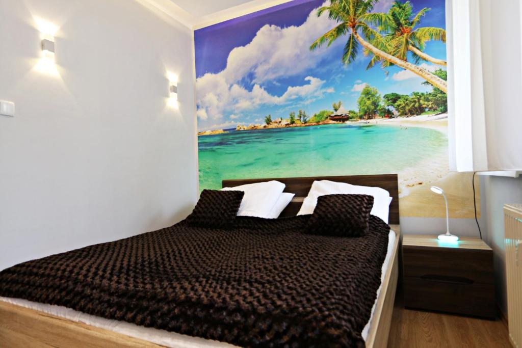a bedroom with a painting of a beach at Helios by Baltic Home in Międzyzdroje
