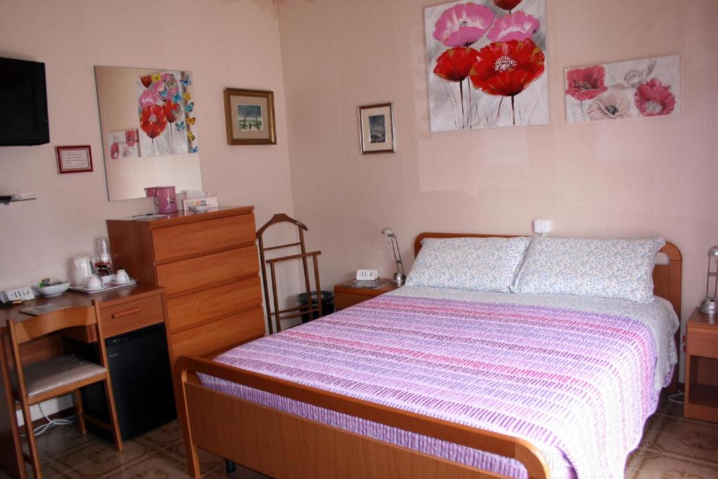 um quarto com uma cama com uma cómoda e uma secretária em A casa di Gianna B&B em Rieti