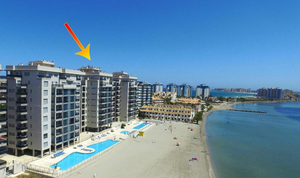 ラ・マンガ・デル・マール・メノールにあるLa Manga Beachclub Apartmentの建物と海を望むビーチの景色を望めます。