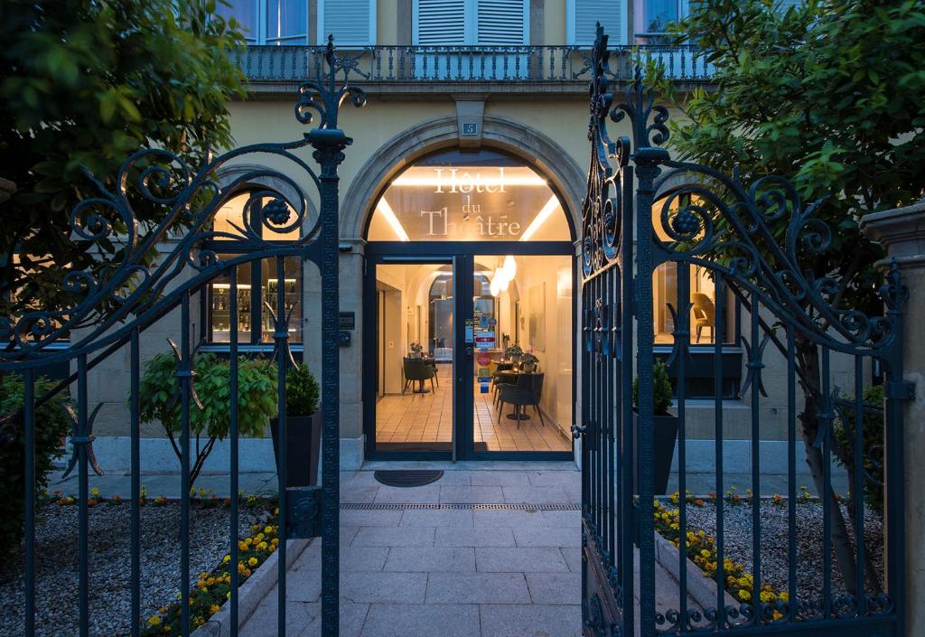 een toegang tot een huis met een ijzeren poort bij Hôtel du Théâtre, Boutique Hôtel in Yverdon-les-Bains