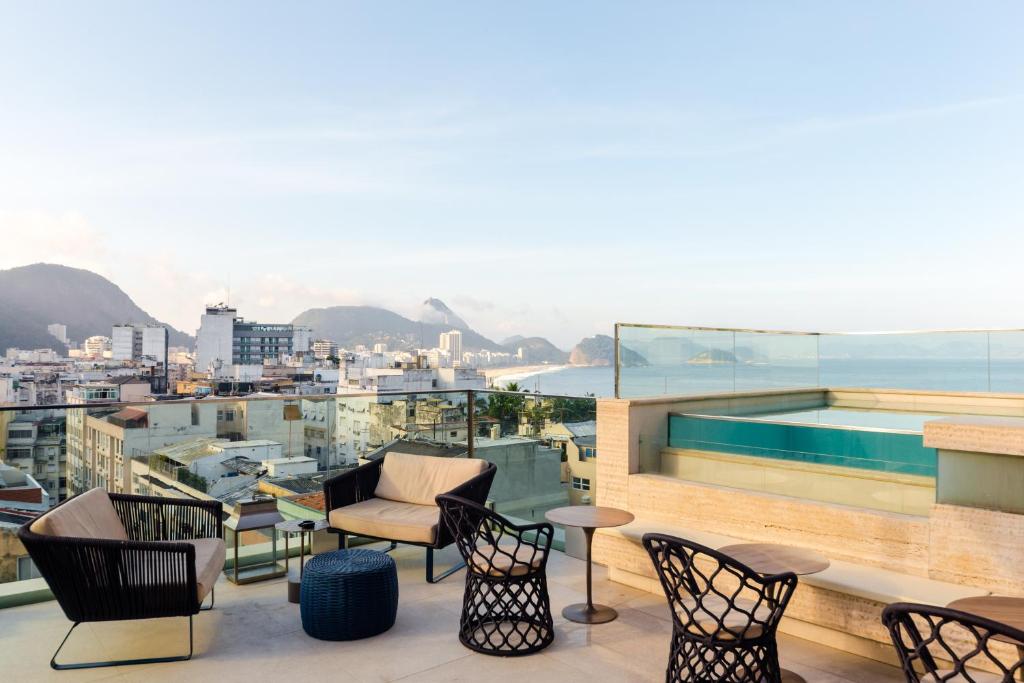 
a patio area with chairs, tables, and benches at Ritz Copacabana Boutique Hotel in Rio de Janeiro
