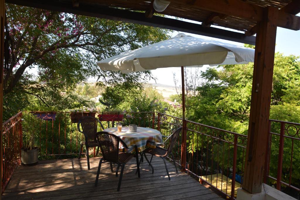 a table and chairs on a deck with an umbrella at Tal Shahar room in Tal Shaẖar