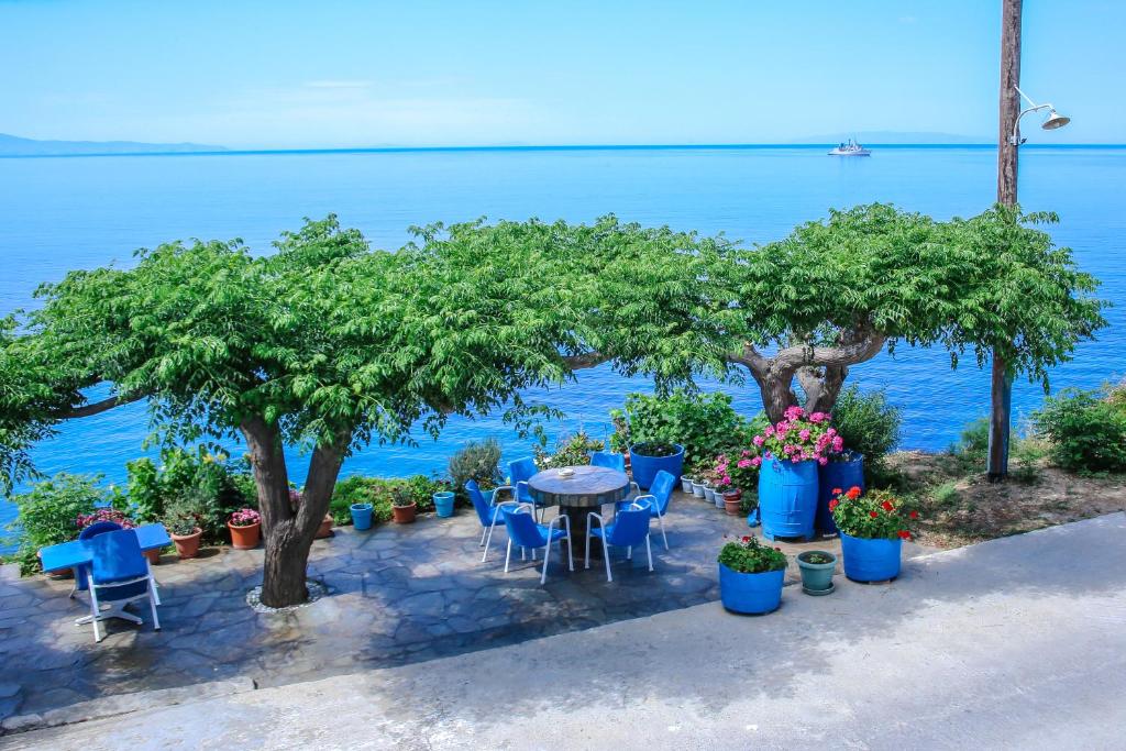 a table and chairs with the ocean in the background at Villa Pitsa in Batsi