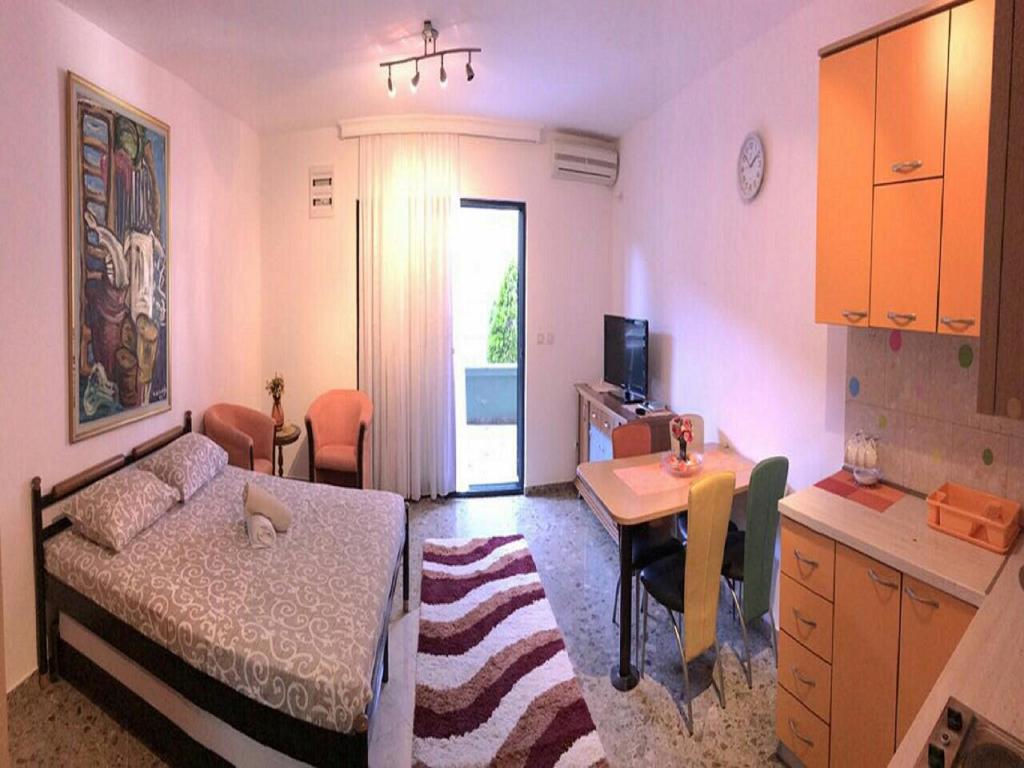 Mały pokój z łóżkiem, biurkiem i stołem w obiekcie Apartment Green Building w miejscowości Sveti Stefan