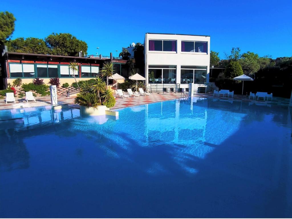 a large swimming pool in front of a building at Eden Park in Marina di Montemarciano