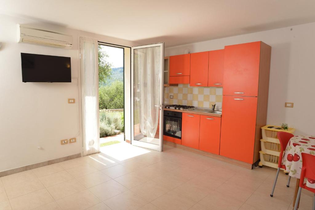 a kitchen with red cabinets and a sliding glass door at Costadoro in Costa dʼOneglia
