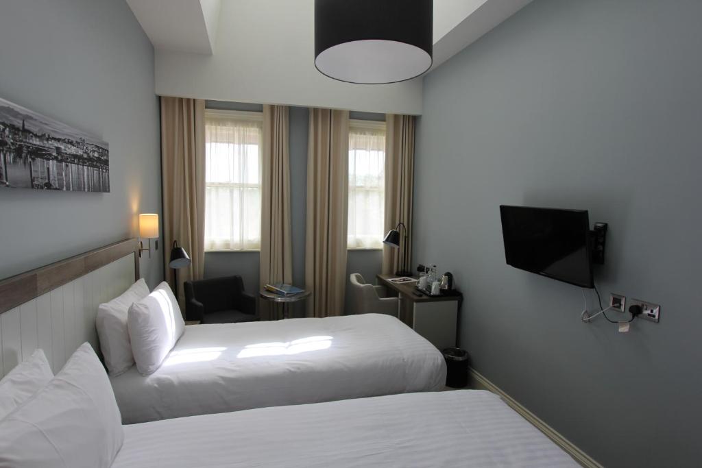 a hotel room with two beds and a television at Yarrow Hotel in Broadstairs