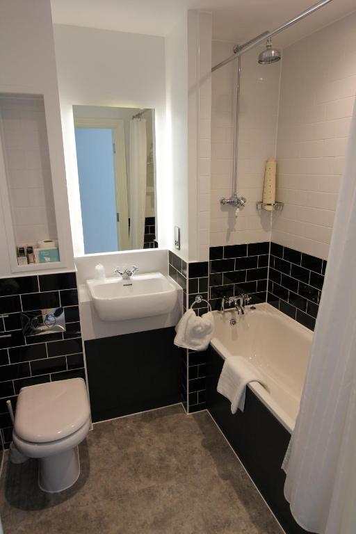 a bathroom with a sink and a tub and a toilet at Yarrow Hotel in Broadstairs