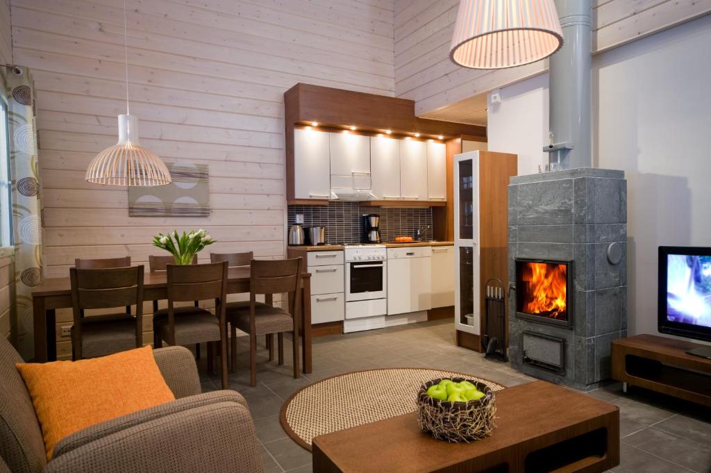 a living room with a fireplace and a dining room at Holiday Club Salla Apartments in Salla