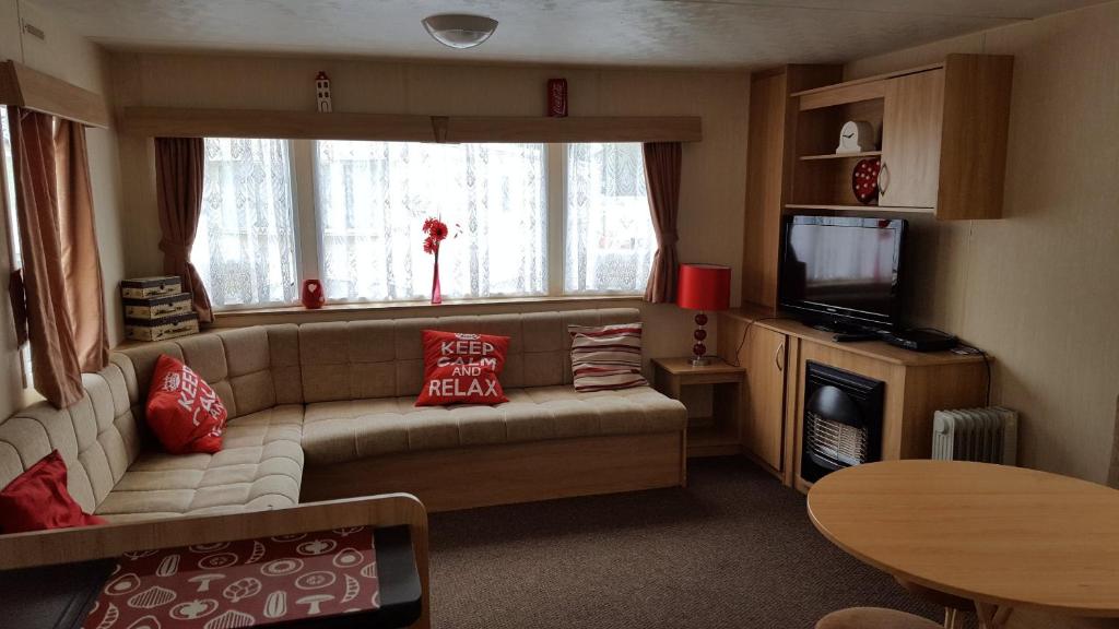 a living room with a couch and a television at Tiggs Caravans in Blackpool