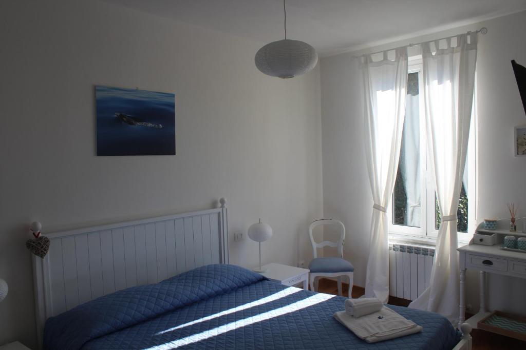 a bedroom with a blue bed and a window at 5 TERRE PELAGOS 2 in Manarola