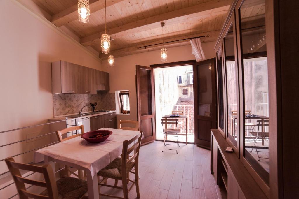 シラクーサにあるAura Ortigia Apartmentsのキッチン、ダイニングルーム(テーブル、椅子付)