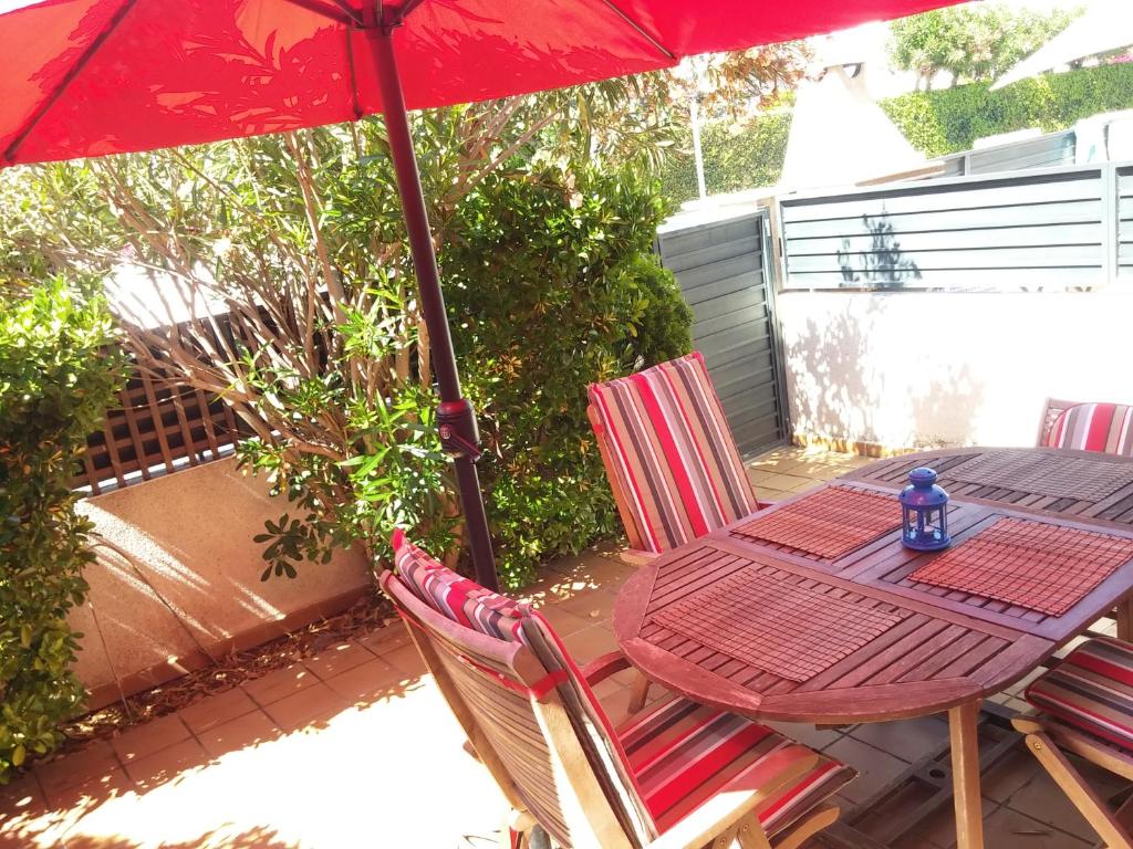 uma mesa e cadeiras com um guarda-sol num pátio em Lydia´s House em Comarruga