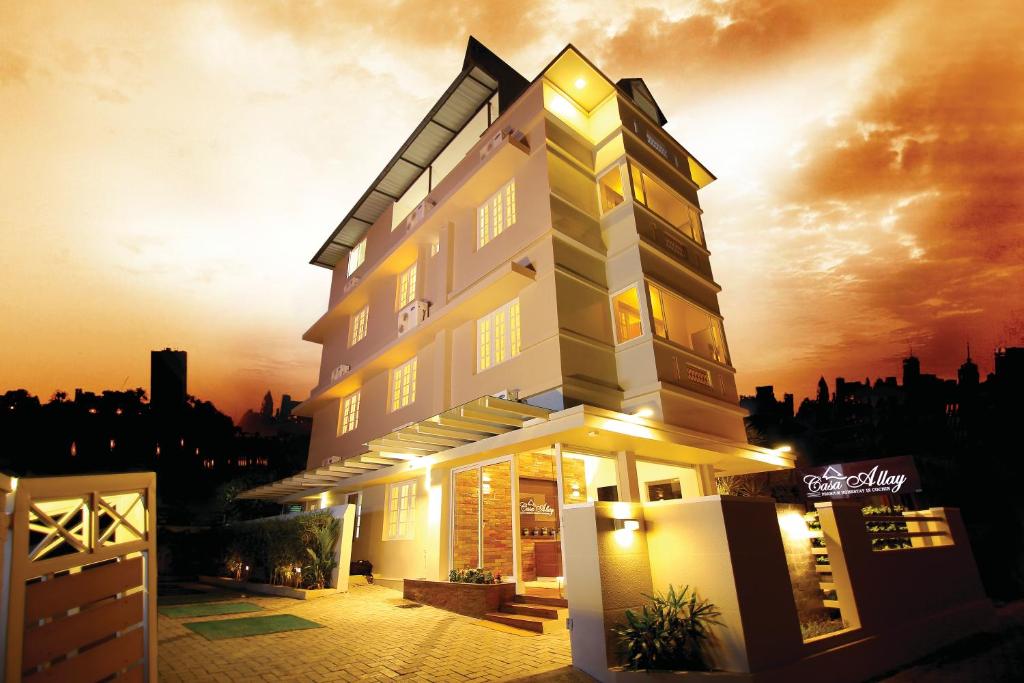 a large building with the sunset in the background at Casa Allay in Cochin