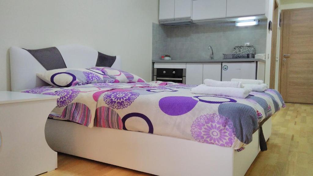 オフリドにあるPark Golden Beach Tasevskiのベッドルーム1室(紫と紫の掛け布団付きのベッド1台付)
