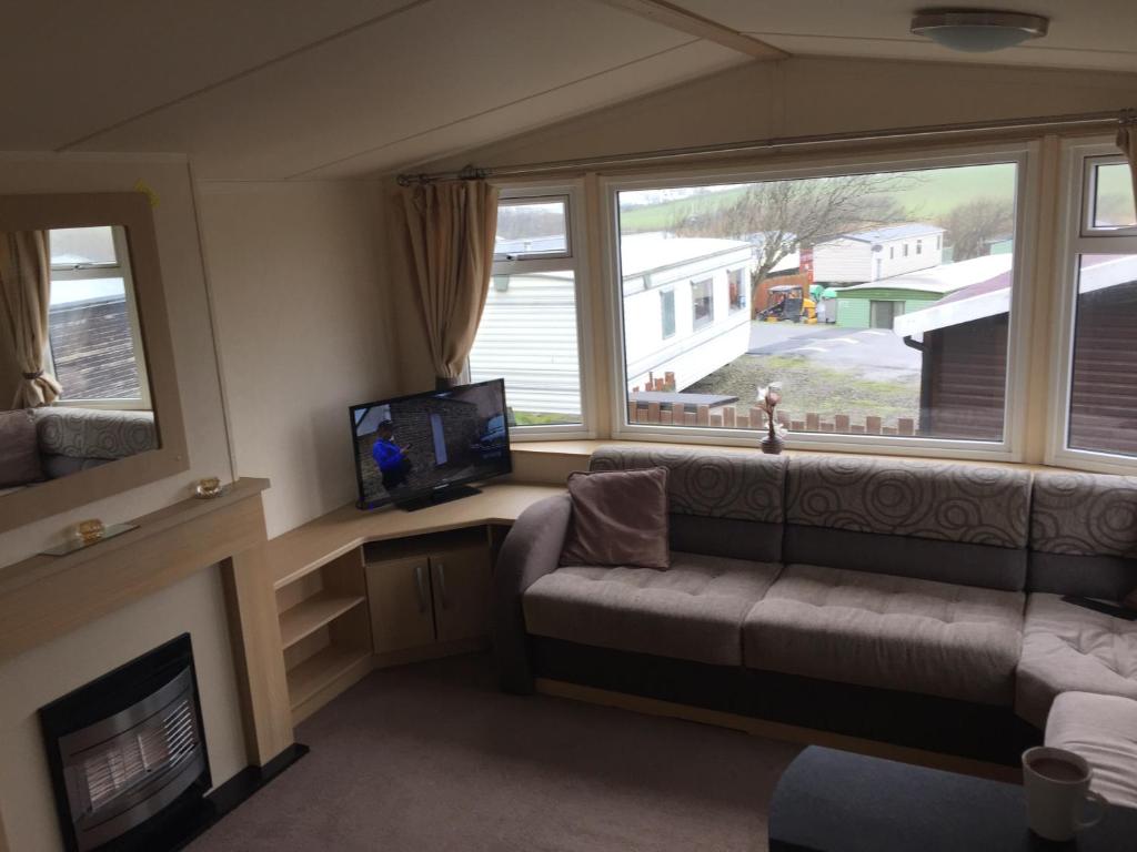 a living room with a couch and a large window at Seaview caravans in Aberystwyth