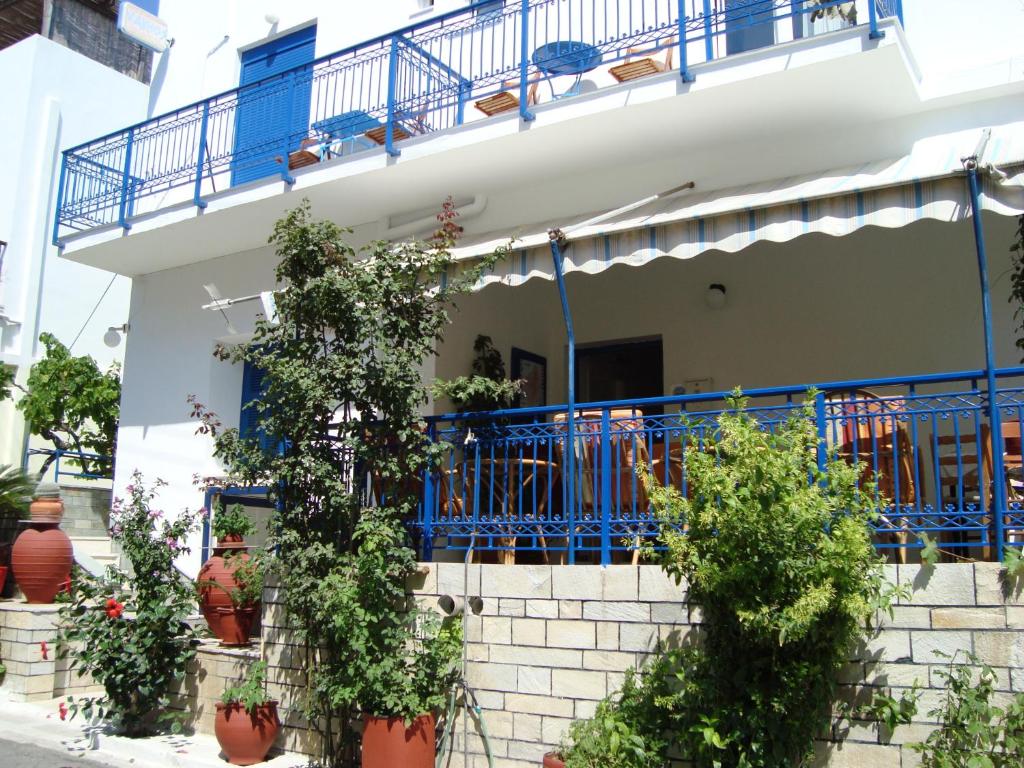 a white house with blue balconies and potted plants at Vakhos in Naxos Chora