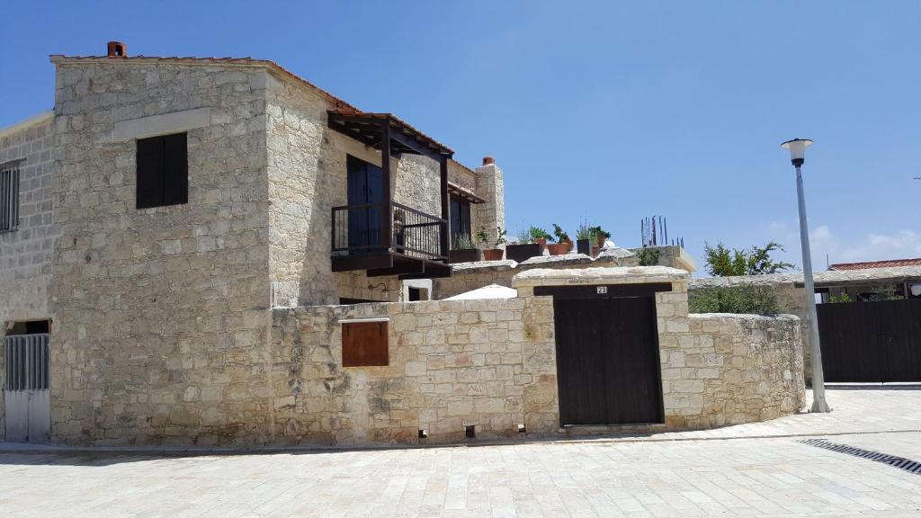 - un bâtiment en pierre avec une porte noire dans l'établissement Michalis Anoyia Traditional Stonehouse, à Kathikas