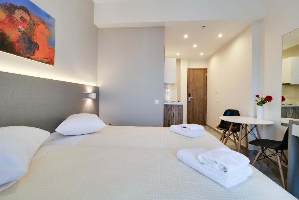 a bedroom with two beds and a table with chairs at Athens Comfort in Athens