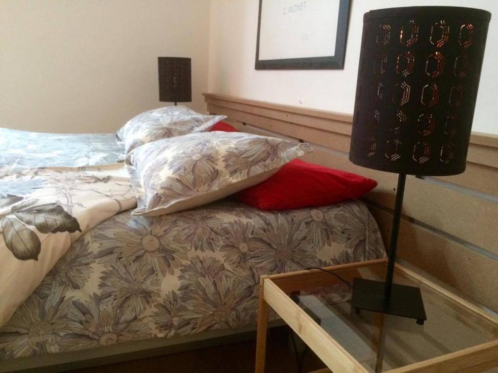 - un lit avec des oreillers et une table avec une lampe dans l'établissement Appart-hôtel Maison de la Lune - petite Auberge d'Etterbeek, à Bruxelles
